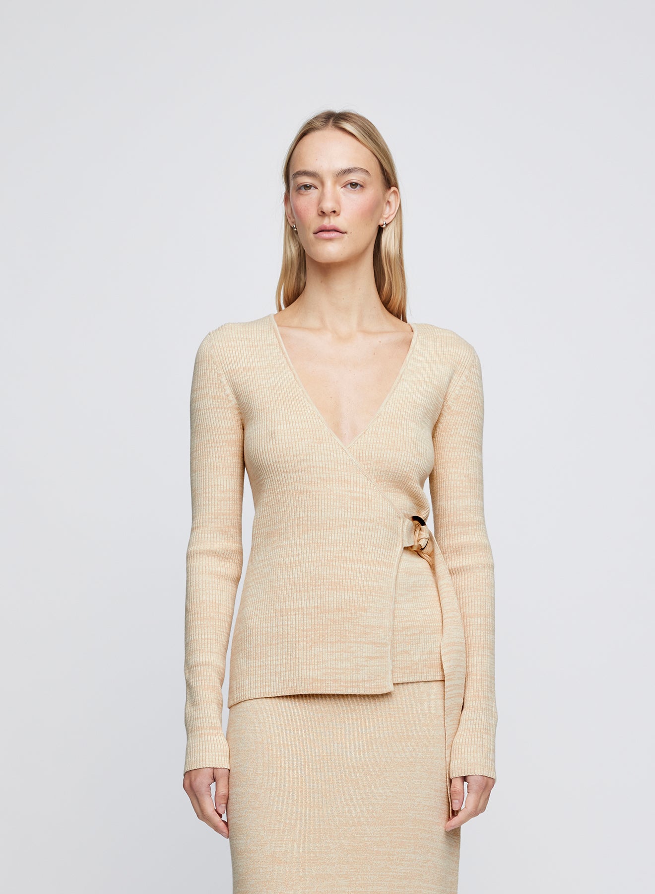 The Anna Quan Bonnie Top in Sand Dune is a classic long sleeve knitted top with a belt closure and deep v cut neckline.