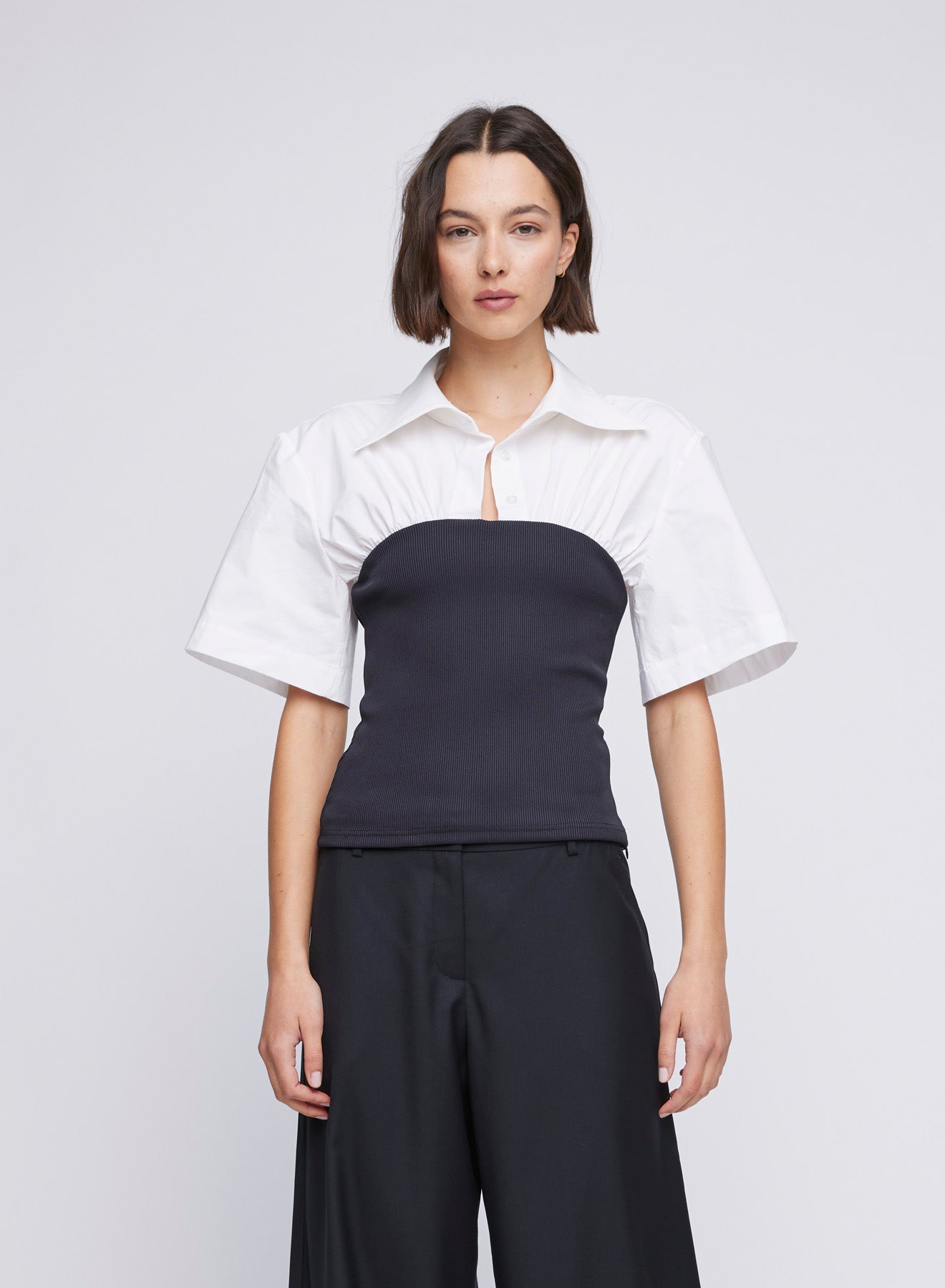 ANNA QUAN Wren Mixed Media Shirt in cotton poplin and contrast jersey ribbed knit. Shirt-style neckline, short sleeves, side zipper closure. Ideal for a classic and versatile everyday or work look.