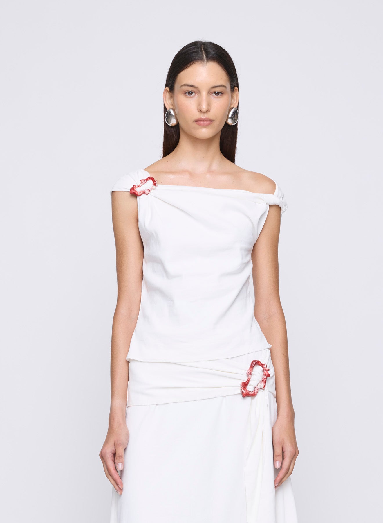 The ANNA QUAN Minkey Top in Ivory Linen features an asymmetrical neckline, cropped length and knot detail with a pop of colour in the curved buckle on the neckline.