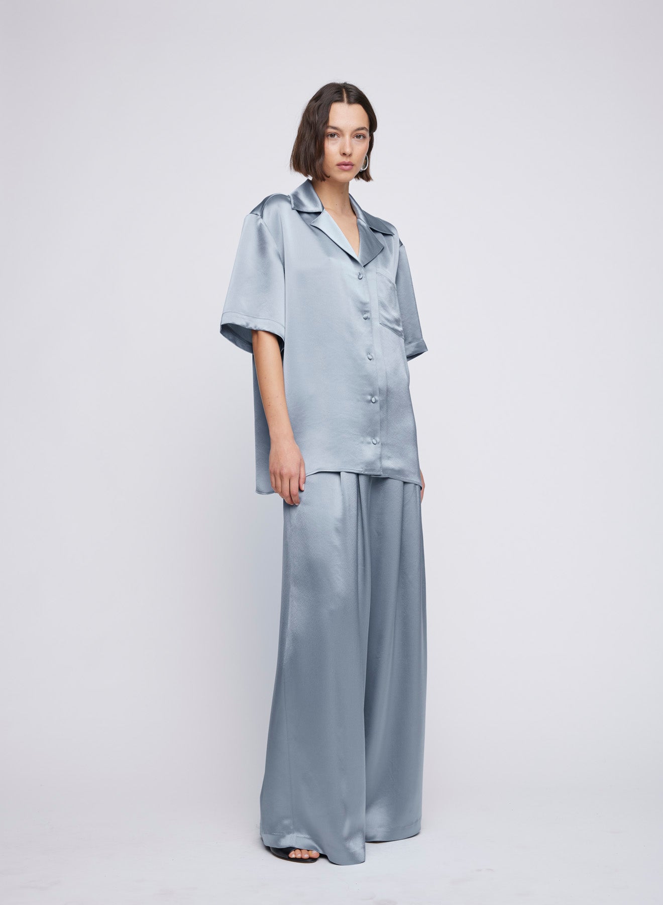 Satin Oversized Camper Collar Short Sleeve Shirt – an relaxed oversized satin shirt, designed with a boxy shoulder, camper collar, breast pocket, and back yoke. Wear with the wide leg matching Mateo Pant. An elevated everyday look worn with sandals or go from day-to-night and pair with heels for a dinner matching set, dinner shirt, party set or event set.